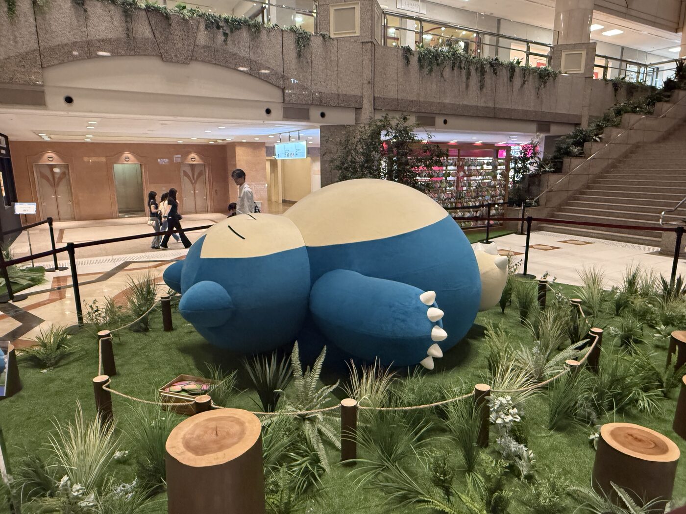 The giant Snorlax seen across the mall floor, with people nearby for scale