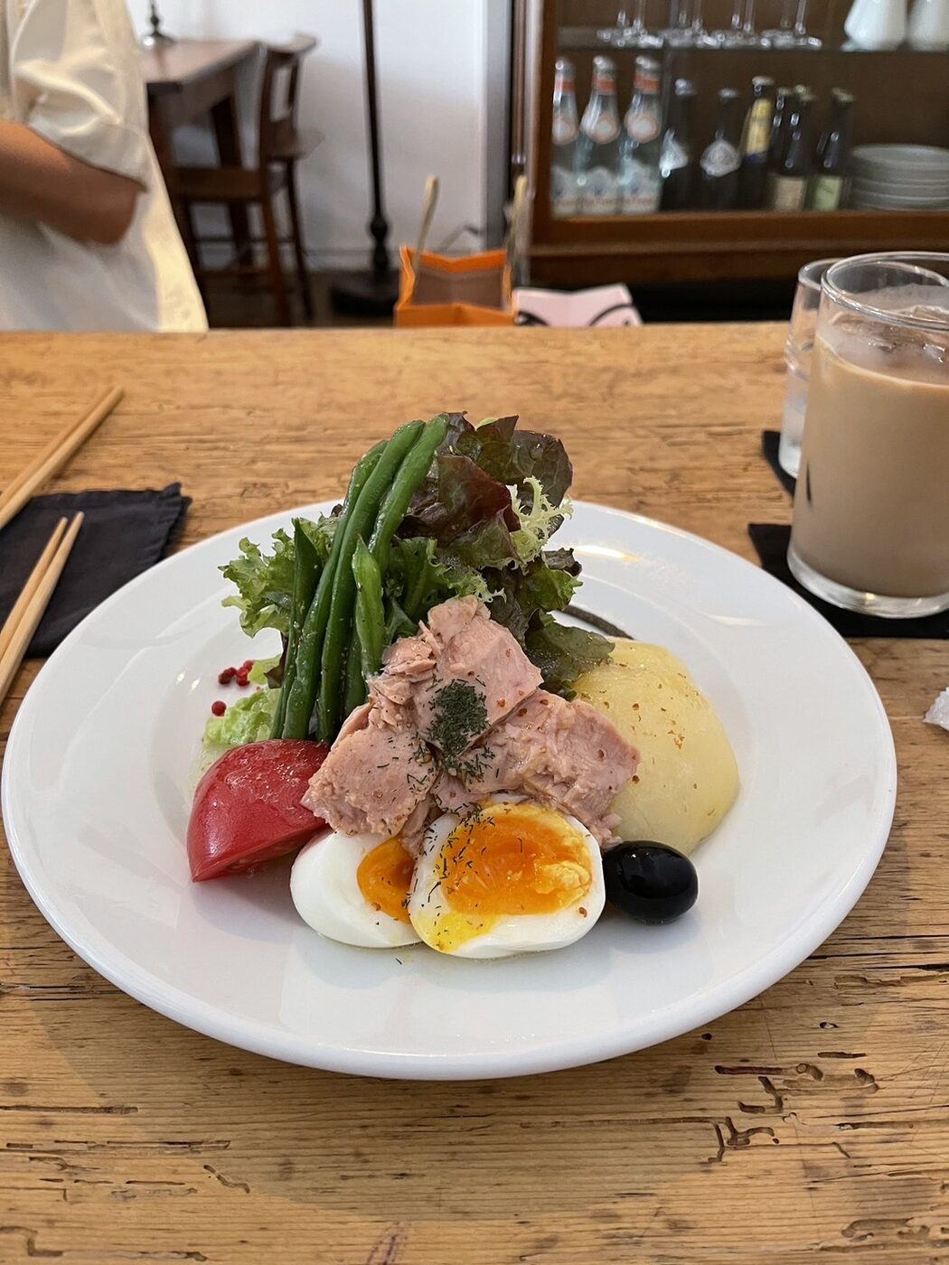 A Nicoise-style salad plate with tuna, egg, potato, tomato, green beans and olives