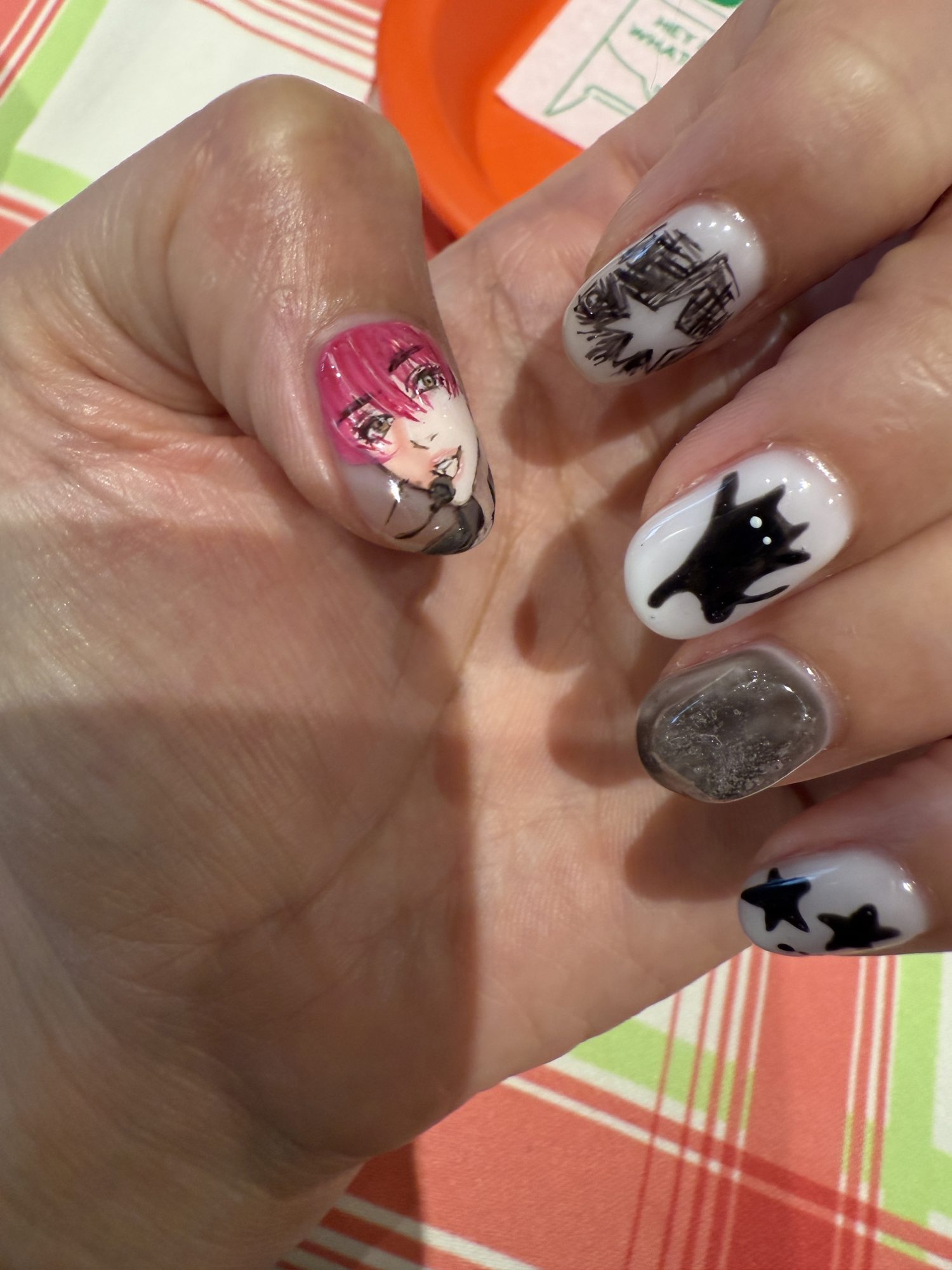 Oshi nails in Tokyo: a hand-painted anime character portrait on the thumb with a black cat and stars