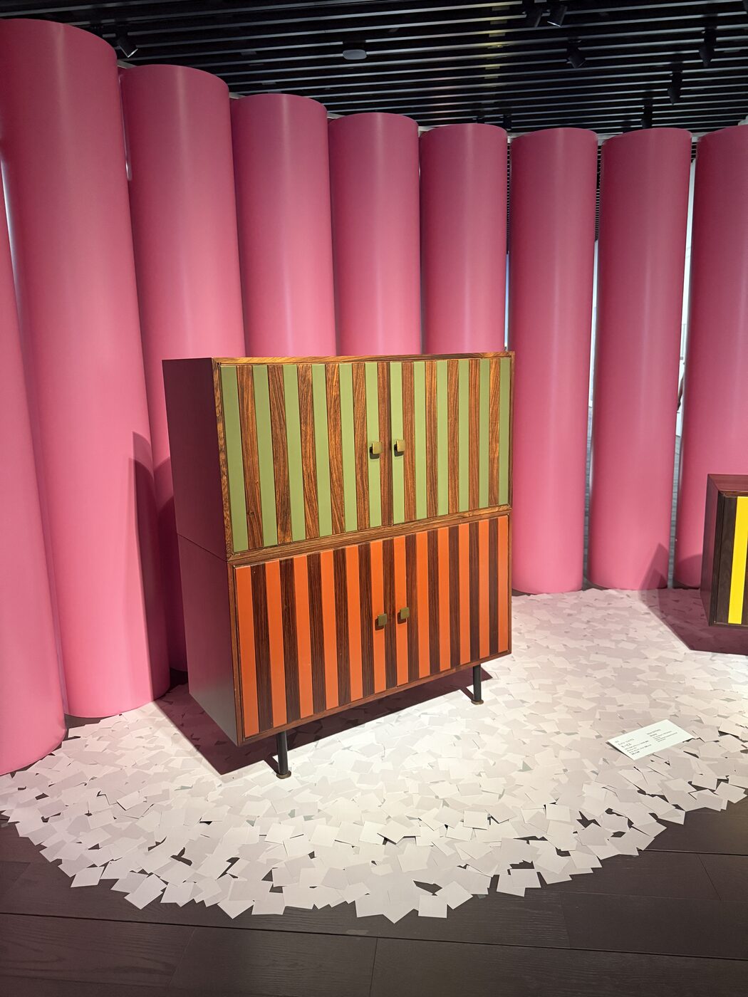 Pink paper-tube walls and a striped Sottsass cabinet on a white paper floor at the Artizon exhibition