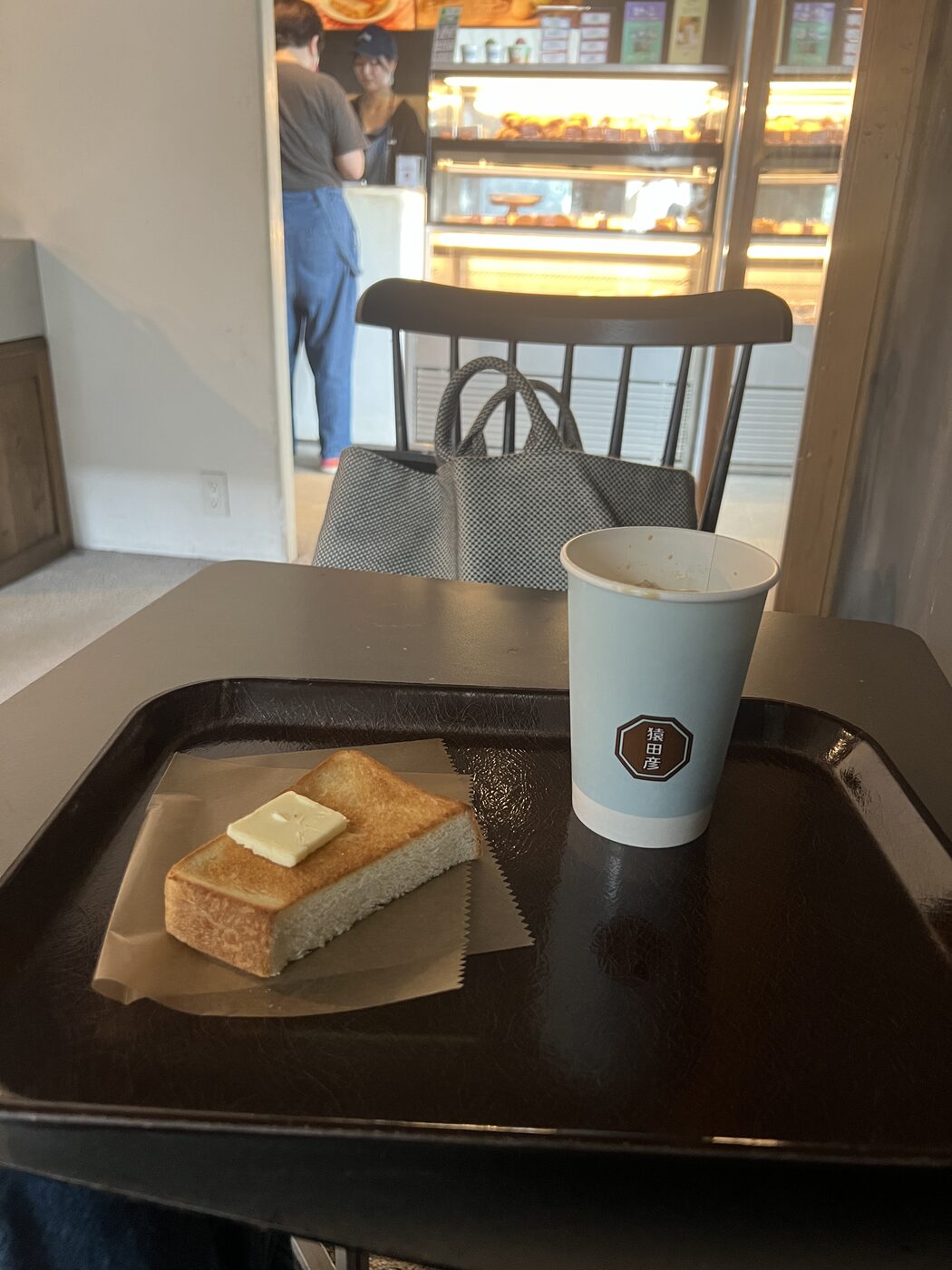 Thick buttered toast and a Sarutahiko coffee cup on a tray