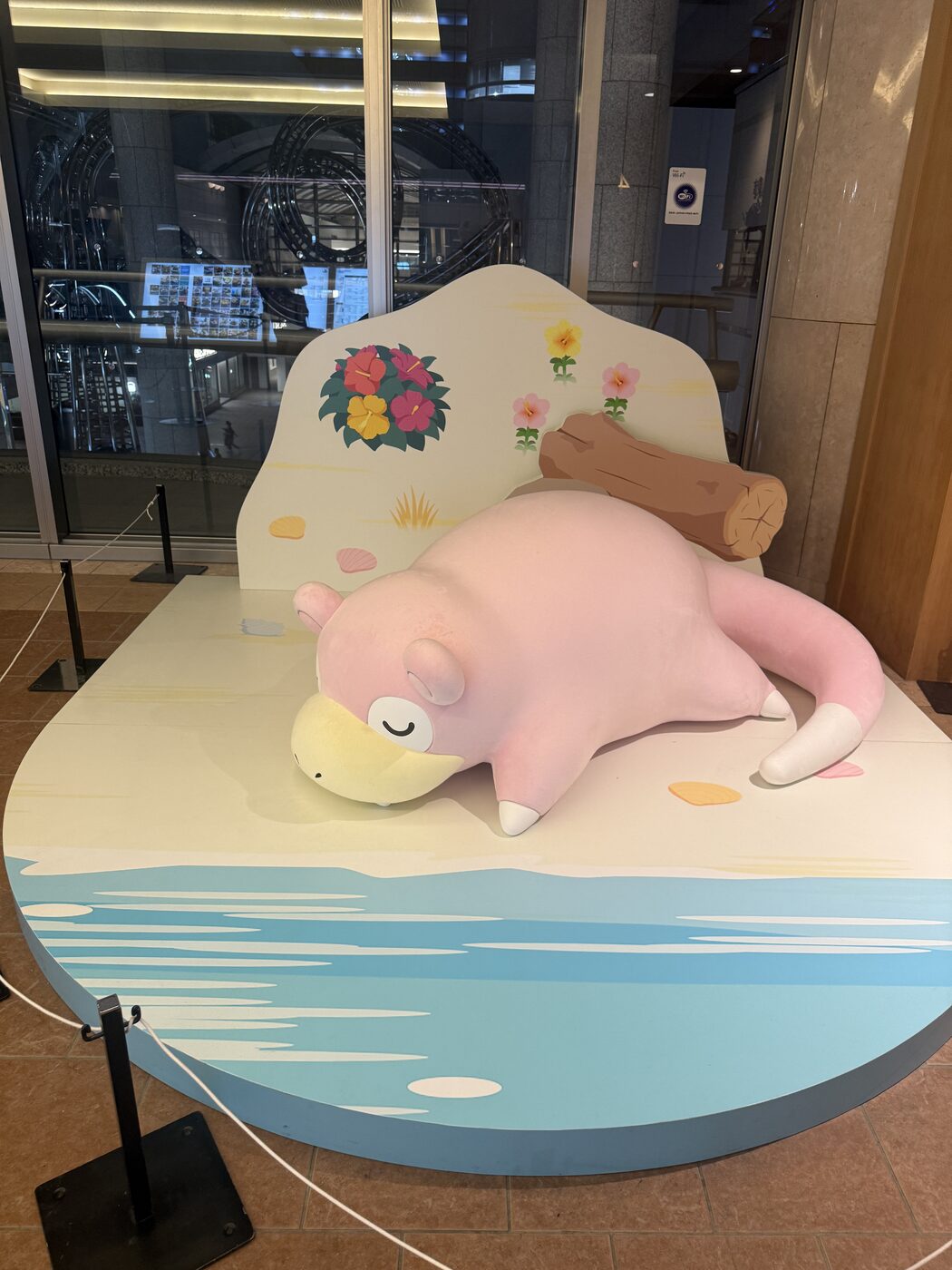 A pink Slowpoke dozing on a small painted beach