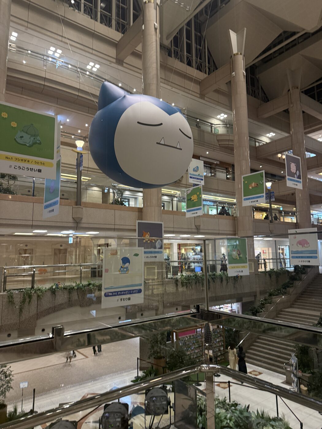 A giant Snorlax head balloon floating in the mall atrium