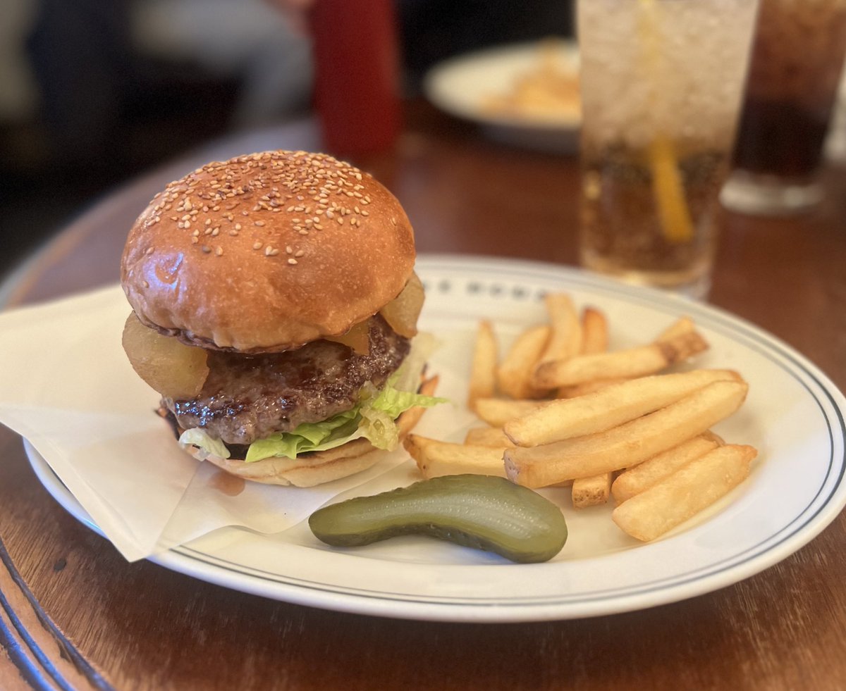 A FIRE HOUSE burger on a branded plate with French fries and a pickle, a cola beside it